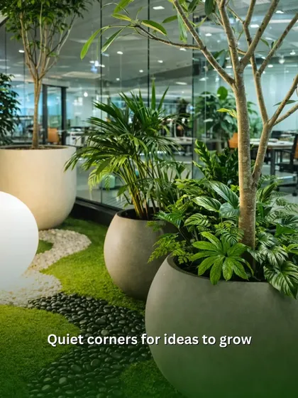 We create quiet corners for ideas to grow. This indoor garden setup uses a mix of trees and smaller plants in modern planters, with a path of river stones, to build a peaceful breakout area within the office.