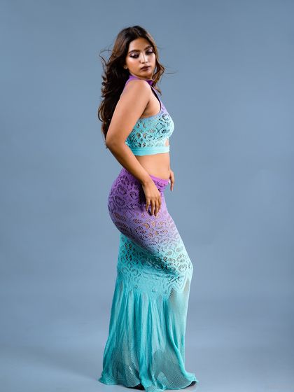 A side-profile fashion portrait in a unique two-tone lace dress. The gradient of purple to teal is the centerpiece of this elegant shot.