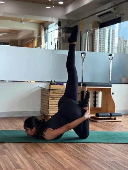 An advanced inversion pose, Urdhva Padmasana in Sirsasana, which requires significant core strength, balance, and concentration.