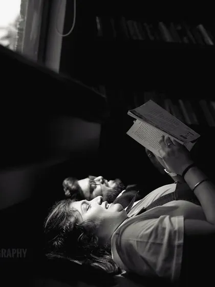 A quiet, intimate moment of a couple reading together, captured in a beautiful black and white composition that focuses on emotion and light.