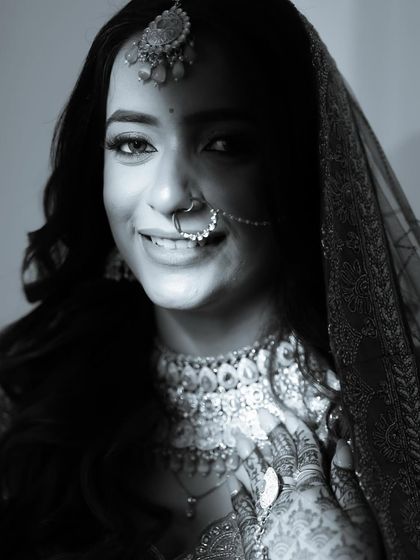 A black and white bridal portrait, with a shadow creating a dramatic play of light on her face.