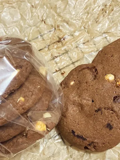 Our rich and chewy double chocolate chip cookies, with some packed in a clear bag for a gift and others ready to be eaten right away.