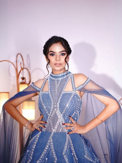 A powerful pose showing the full gown and its dramatic cape sleeves.