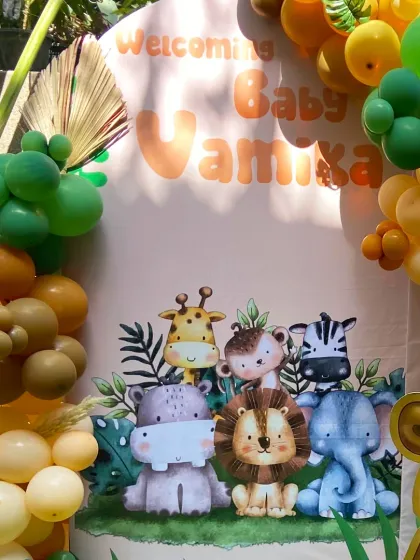 A closer look at our "Welcoming Baby Vamika" backdrop. The cute, illustrated safari animals and the organic balloon garland in jungle tones make for a perfect photo spot.