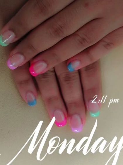 A playful rainbow French manicure where each tip has a soft gradient of different bright colors.