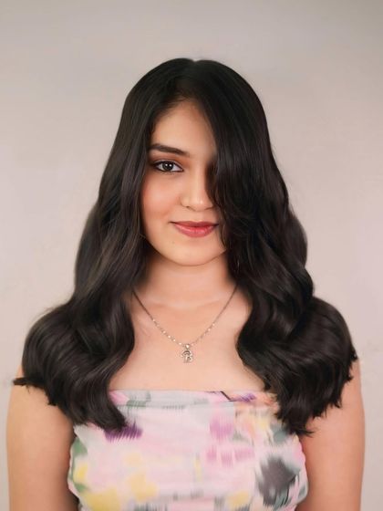 Layers on top, fire underneath. This long, dark hairstyle is styled with soft waves to create a classic, glamorous look.