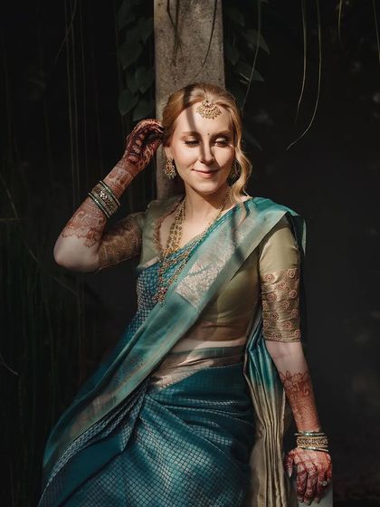 A candid portrait of the bride, her stained hand gently touching her hair.