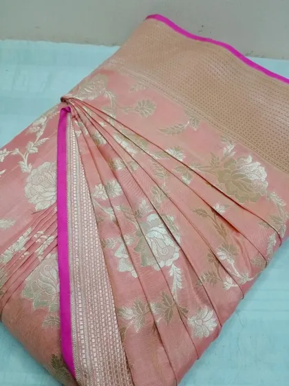A delicate peach-pink Banarasi saree with silver floral motifs.