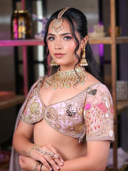 This graceful and traditional look features soft pink eyeshadow and a flawless base, paired with a beautiful pastel lehenga and kundan jewelry.