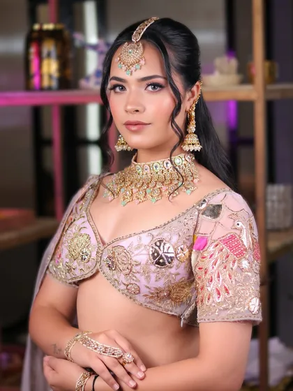 A direct gaze from the model, showcasing the soft glam makeup that enhances her features without overpowering them. The half-up hairstyle complements the look perfectly.