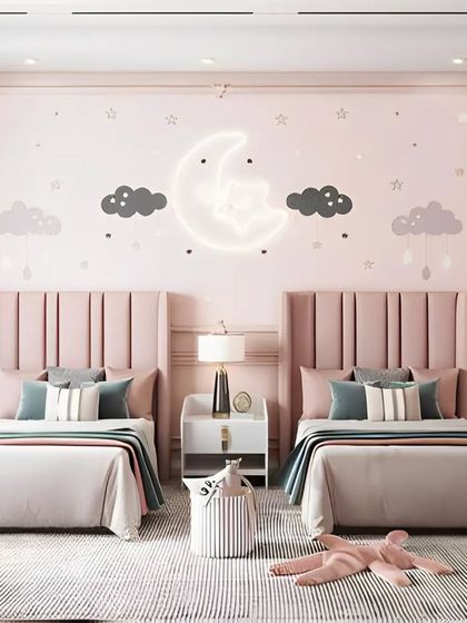 A celestial-themed twin room in soft pink hues. The design is centered around a neon moon-and-star light fixture, with tall upholstered headboards and hanging pendant lights adding a touch of elegance.