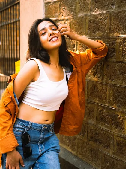 A joyful, sunny portrait against a textured brick wall. This shot is all about capturing a happy and carefree personality.