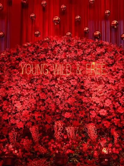 For a cocktail night that’s young, wild, and free, we designed this spectacular photo backdrop. A massive wall of crimson roses is illuminated by custom neon signs, creating a bold, high-energy focal point perfect for capturing fun and unforgettable memories.