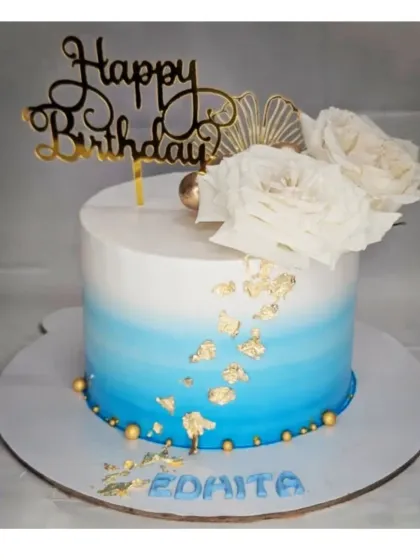 An elegant blue ombre cake with gold leaf accents. This chocolate mousse cake is topped with beautiful white wafer paper flowers.