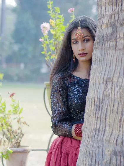 This shot uses the tree as a framing device, drawing attention to the model's look. It's a classic technique for outdoor portrait photography.