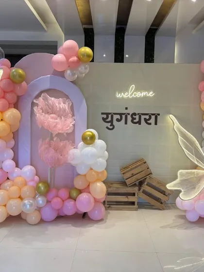 A closer view of the pastel-colored butterfly theme setup, highlighting the organic balloon garlands and wooden crate props.