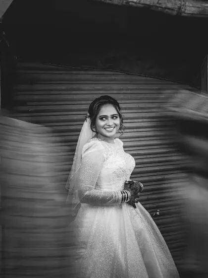 An artistic black and white bridal portrait using a slow shutter speed to create motion blur. The bride remains in sharp focus amidst the moving city.
