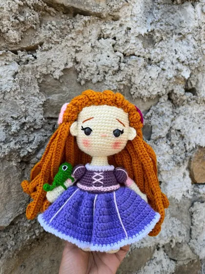 I enjoy bringing beloved characters to life, like this Rapunzel doll. I focused on getting the details right, from her long, braided orange hair to the little Pascal on her arm.