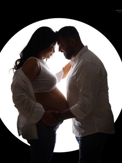 A beautiful black and white silhouette of a couple. Their closeness and the way they hold the baby bump together speaks of their shared journey.