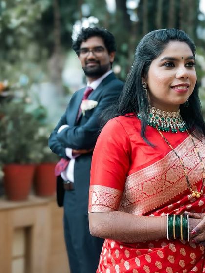 A creative portrait with the bride in focus and the groom standing proudly in the background. A modern composition for a stylish couple.