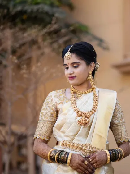 I believe in elegance that feels effortless. For this muhurtham look, I used soft, earthy tones and a subtle highlight to enhance her natural features, ensuring the makeup looked fresh and timeless alongside the classic off-white silk saree.
