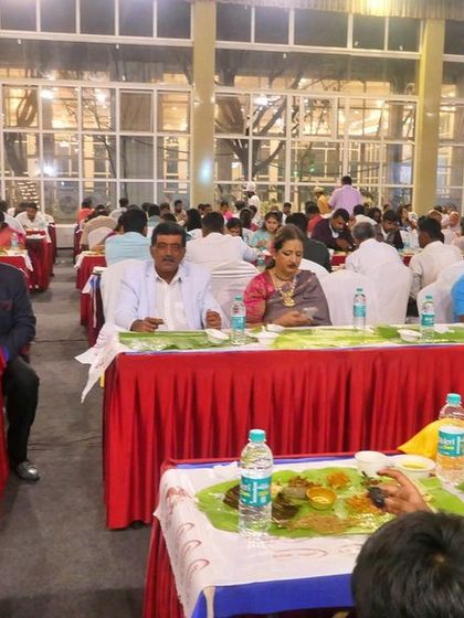 A full dining hall with guests enjoying their meal on banana leaves. I can comfortably manage catering for large gatherings in venues like the Palace Grounds.