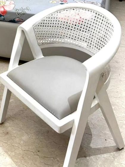 Add a touch of elegance to your bedroom with this beautiful chair. It features a white-finished wooden frame and a gracefully curved back with cane webbing. The wood color and fabric are fully customizable.
