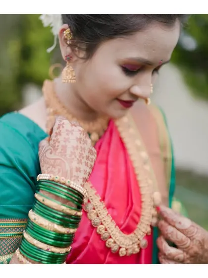 A close-up shot focusing on the details of the model's jewelry and the rich texture of her saree. This type of shot is essential for a complete fashion portfolio.