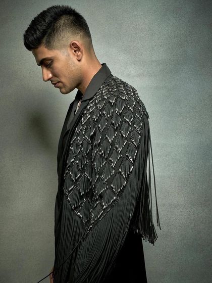 A quiet, profile shot of Shubman Gill. This angle showcases the unique shoulder detail and texture of the jacket, proving that high-fashion tailoring is an art form.