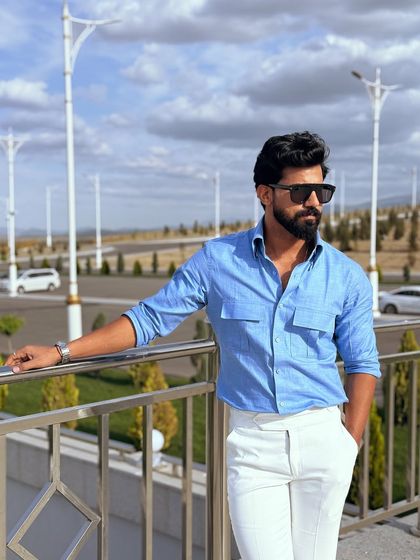 A relaxed pose against a railing, this image highlights the shirt's comfortable fit and practical double-pocket design.