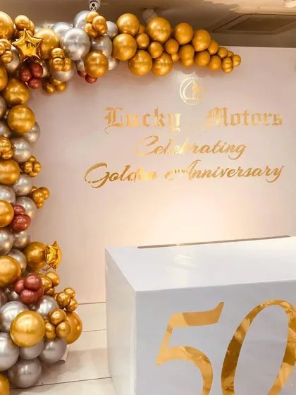 We helped Lucky Motors celebrate their Golden 50th Anniversary with this clean and elegant photo backdrop. The design uses a chrome gold and silver balloon arch to frame the custom gold-foil branding, creating a professional and high-end look for their corporate event.