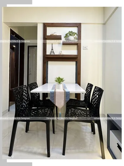 A close-up of the foldable dining table in the 1BHK apartment. When open, it provides comfortable seating for four. When folded, it becomes a decorative wall unit with shelves, demonstrating our focus on smart, functional furniture.