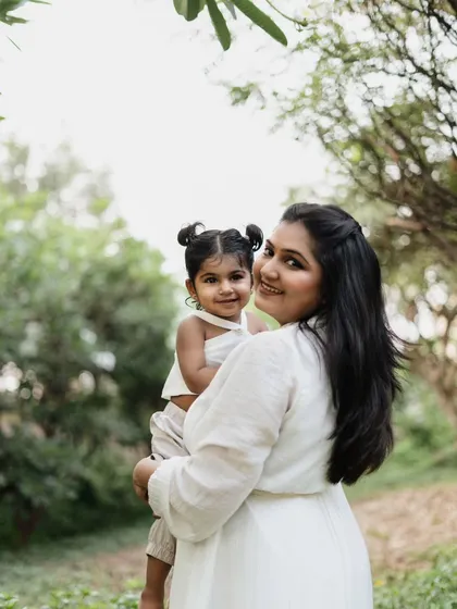 A lovely mother and daughter portrait taken outdoors. The natural greenery provides a soft and beautiful backdrop for their special bond.