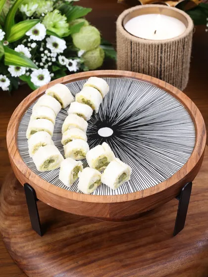 A larger Moon Ray stand serving traditional Indian sweets. The intricate black and white pattern provides a beautiful backdrop, elevating the presentation of any dessert.