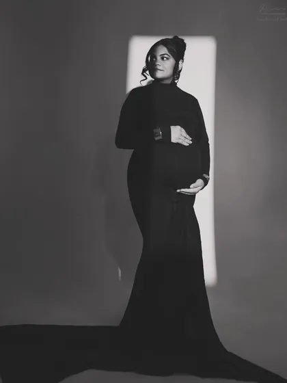 A full-length silhouette against a sliver of light. This artistic black and white portrait is all about creating a dramatic and elegant shape that celebrates your pregnancy.