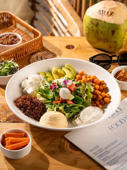 A large, healthy salad bowl with fresh avocado, chickpeas, and feta. This shot is vibrant and full of texture.