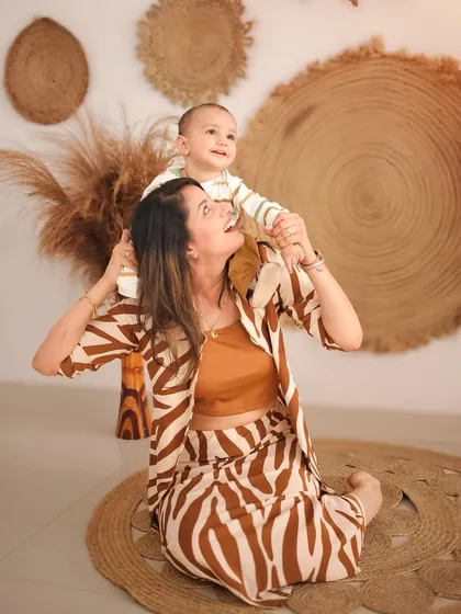 A playful moment between mother and son during a boho-themed studio shoot. The earthy tones, natural textures, and coordinated outfits create a warm and stylish atmosphere. I love capturing these lighthearted interactions that show a mother's love.