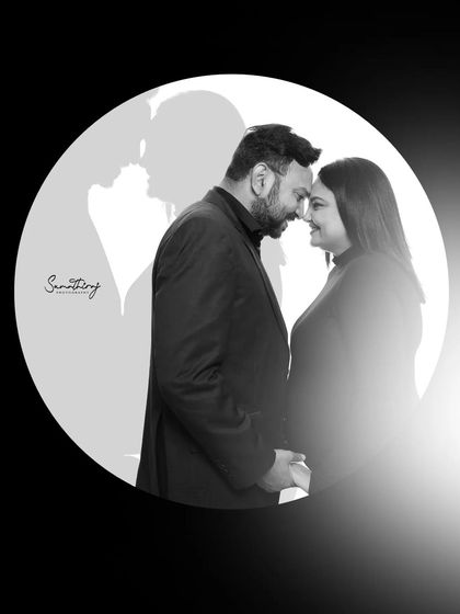 A creative black and white portrait using a circular frame and shadow play. This artistic shot tells a story of love and unity, with the couple's shadows forming a heart.