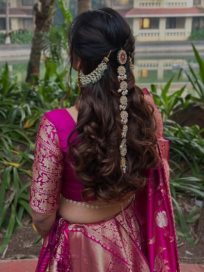 Another angle of the half-up style, showing how the hair jewelry beautifully complements the bride's magenta silk saree.