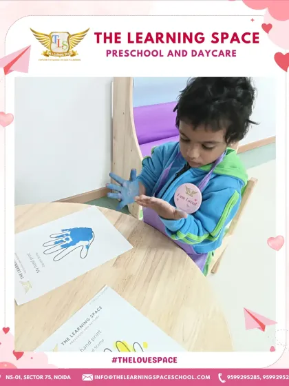 A child carefully places his painted hand on paper. This activity requires focus and control, helping to refine motor skills in a fun and personal way.