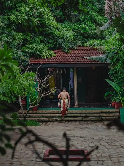 The groom, seen from behind, walks up the steps into one of our heritage buildings, a cinematic shot full of anticipation.