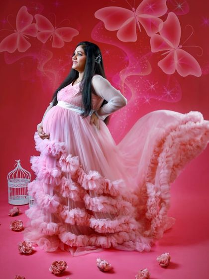A fairytale-themed studio shoot with a pink ruffled gown. The butterfly effects and pink background create a magical and dreamy atmosphere.
