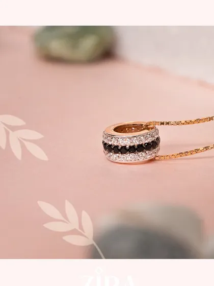 A statement pendant featuring concentric circles of black and white CZ diamonds on a sleek chain.