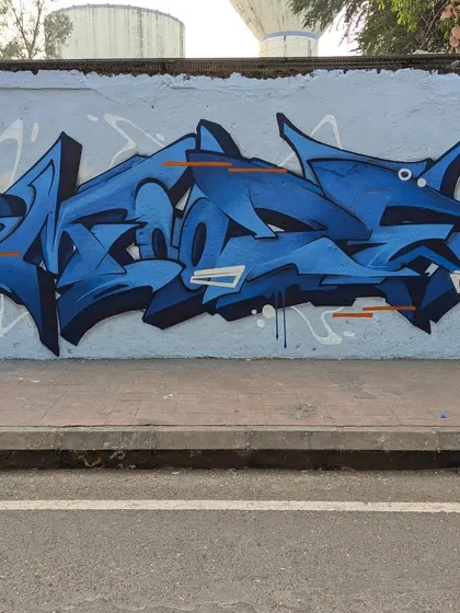 Sometimes it's all about the letters. This is a pure wildstyle piece, focusing on complex forms, clean lines, and a cool blue color palette. It was a chill jam session with artists from Paris, Bahrain, and Mumbai, right here on our streets.