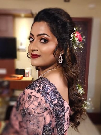 Another angle of the hairstyle, showing the soft curls and floral accessories from the back.