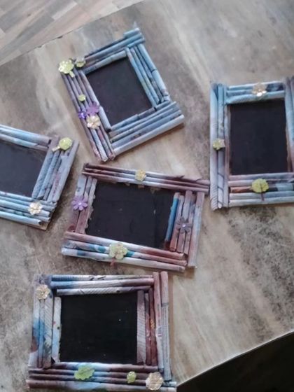 A collection of unique photo frames made from rolled-up newspaper and decorated with small flowers. This is a great example of our upcycling craft projects.