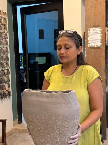 A student holding her large, hand-built vessel. There's a real sense of accomplishment in creating something so substantial with your own two hands.