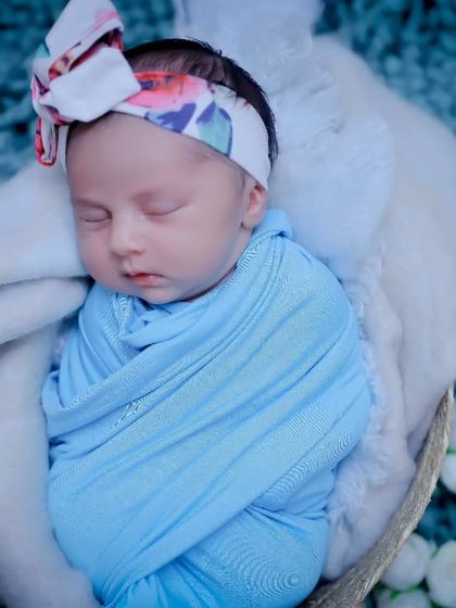 Swaddled in blue, this sleeping baby looks so peaceful. Our newborn sessions are designed to be calm and soothing for your little one.