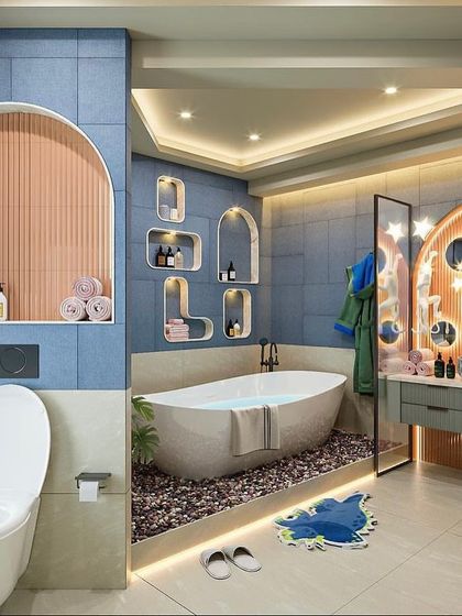 A creative kids' bathroom design with a fun, asymmetric theme. The space uses a mix of blue and white tiles, an arched niche, and a freestanding tub set on a bed of pebbles with under-lighting.