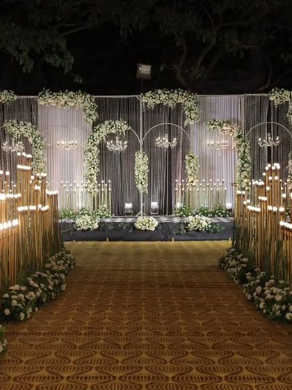 The entrance to Roshan and Ria's reception was designed to be a breathtaking experience. A long aisle flanked by modern, illuminated bamboo structures and white florals led guests to the main event, building anticipation with every step.